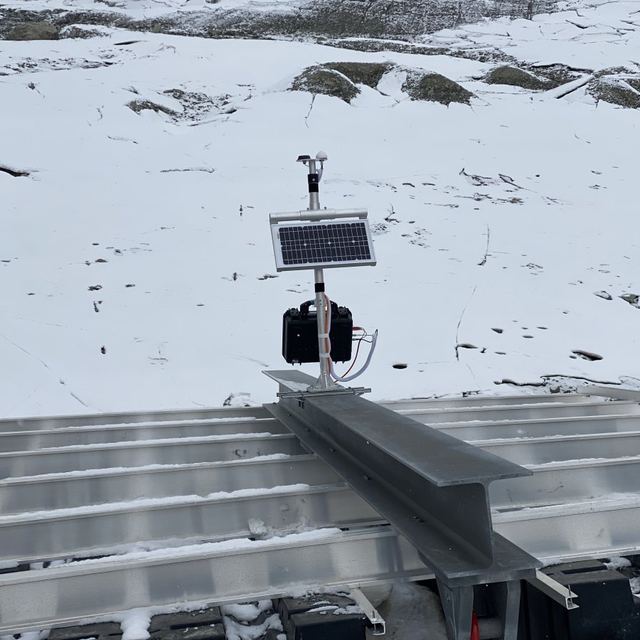 Mât de mesure avec panneau solaire et coffret, fixé sur une structure aluminium